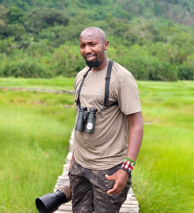 John Gitiri, founder and lead guide, in the field with binoculars